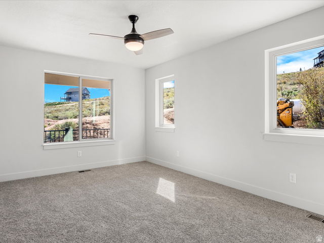 1159 North Broad Hollow Road Garden City, UT 84028 - Photo 37 of 55 Room with neutral gray carpeting, white walls, and a contemporary ceiling fan with integrated lighting