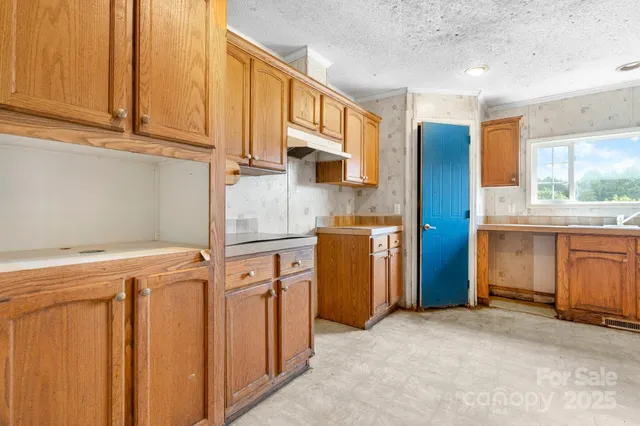 a kitchen with stainless steel appliances granite countertop a stove a sink a refrigerator and a microwave