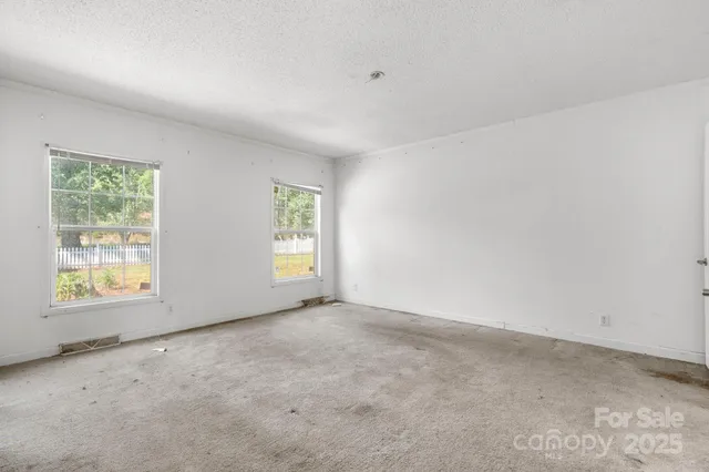 an empty room with windows and closet