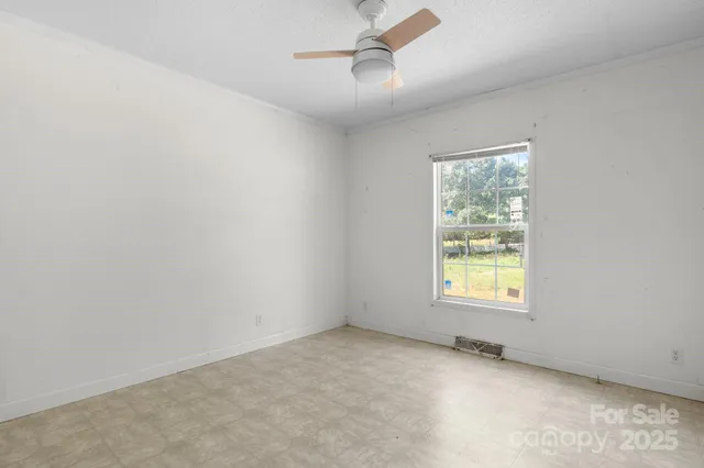 a view of an empty room with a fireplace and a large window