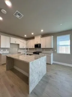 a large kitchen with kitchen island a sink stainless steel appliances and cabinets