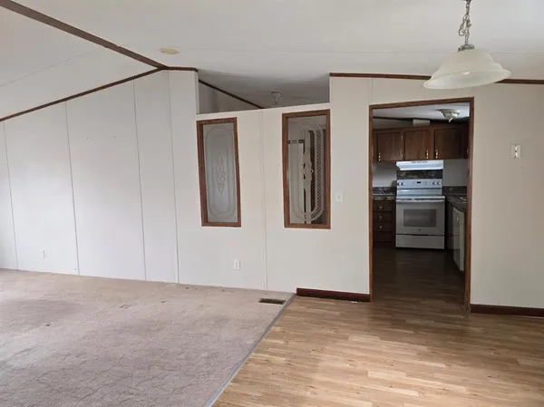 a view of an empty room with closet and a window