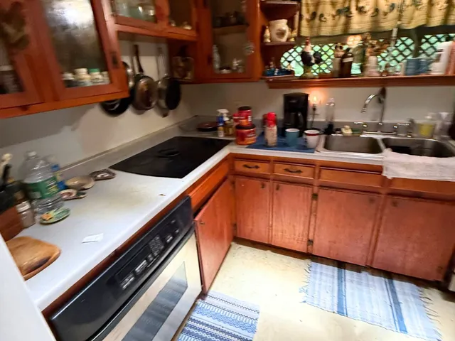 a kitchen with a sink dishwasher and cabinets with wooden floor