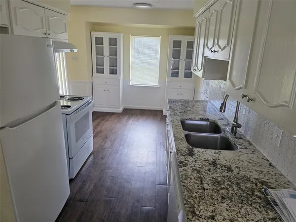 an empty room with wooden floor ceiling fan and window