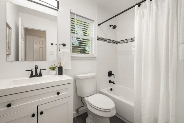 a bathroom with a sink toilet a mirror and shower