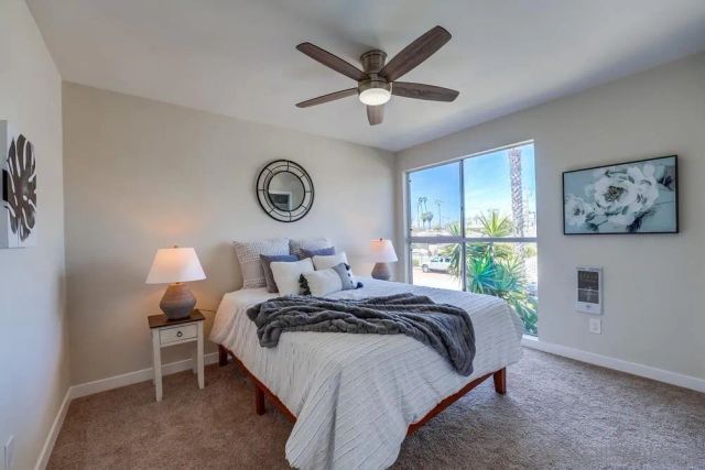a bedroom with bed and a large window