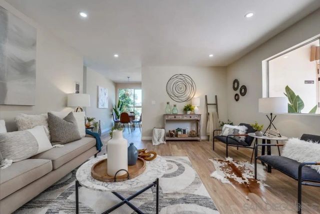 a living room with furniture a clock on wall and a window