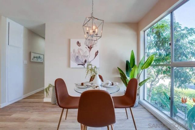 a dining room with furniture potted plants and wooden floor