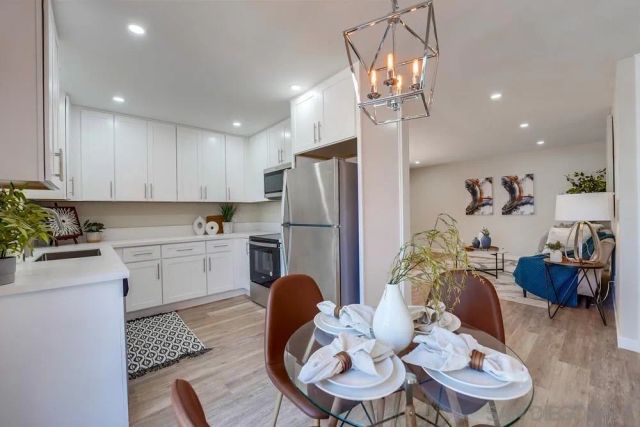 a kitchen with sink refrigerator dining table and chairs