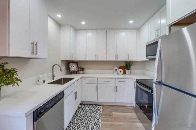 a kitchen with a sink a refrigerator and cabinets