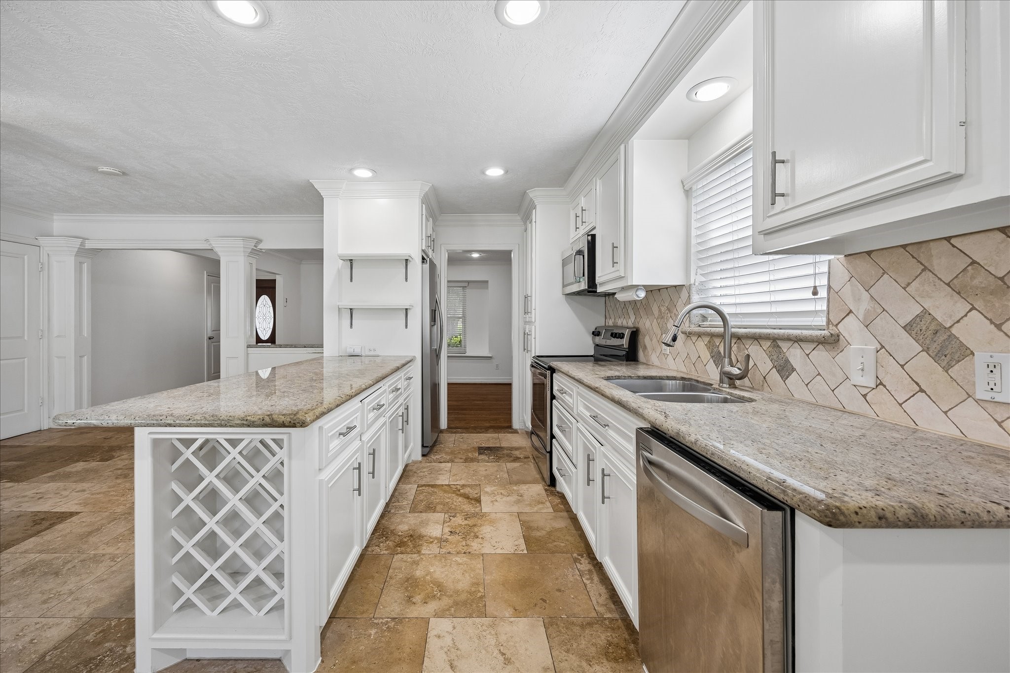 5019 Kinglet Street Houston, TX 77035 - Photo 8 of 24 Exquisitely appointed kitchen boasts granite counters, chevron pattern stone backsplash, high-end stainless appliances & abundant cabinet space. Stainless refrigerator conveys with home!