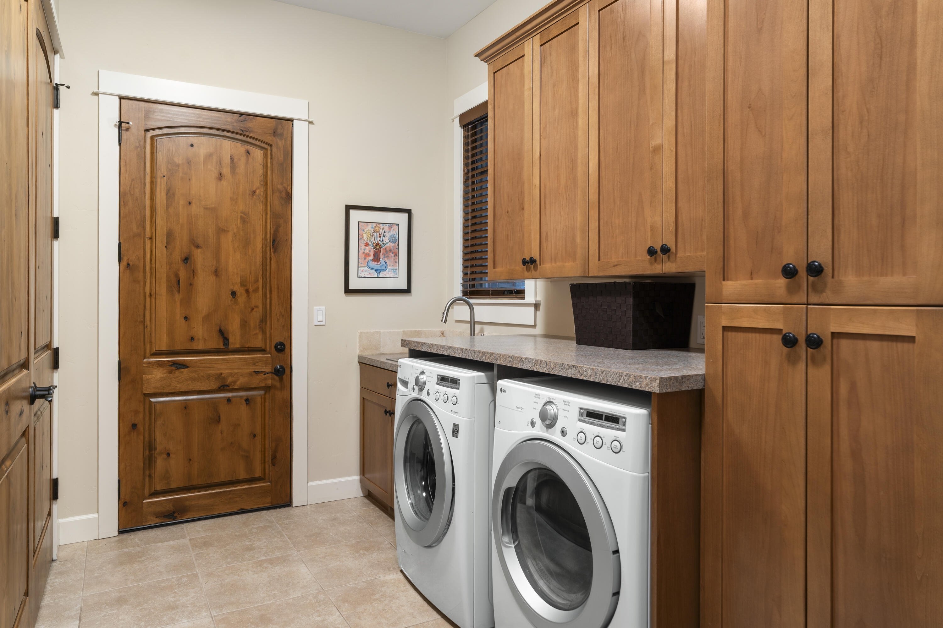 56155 Sable Rock Loop, Unit 277 Bend, OR 97707 - Photo 45 of 63 The spacious laundry room offers extensive cabinetry, abundant counter space, and a utility sink for added convenience and organization.