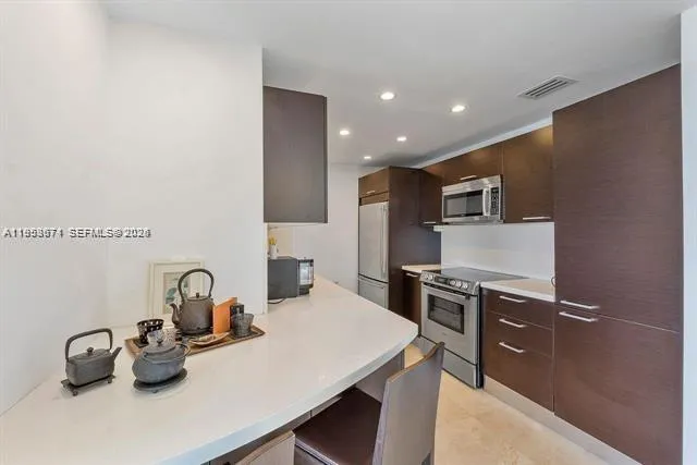 a kitchen with kitchen island a sink stove and refrigerator