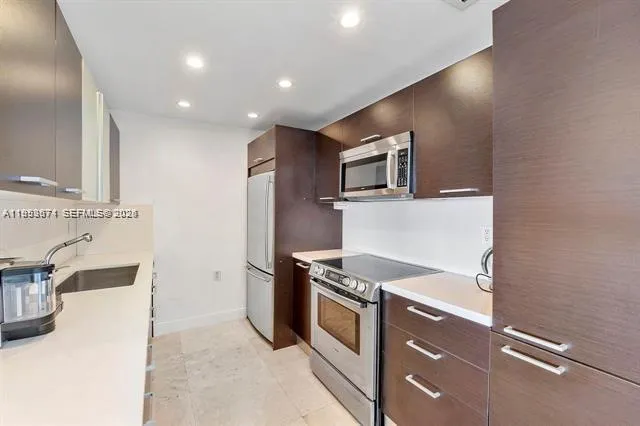 a kitchen with a sink and steel appliances