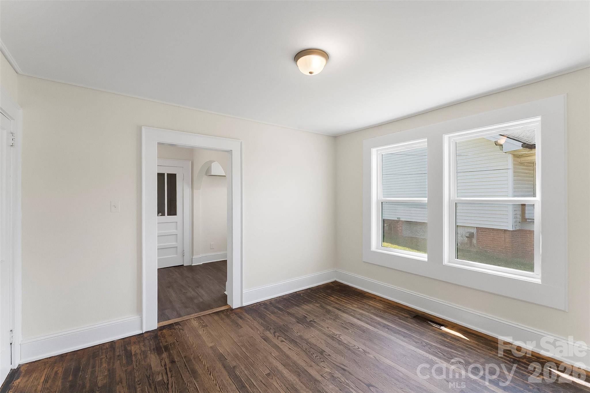608 East Concord Street Morganton, NC 28655 - Photo 5 of 23 an empty room with wooden floor and windows