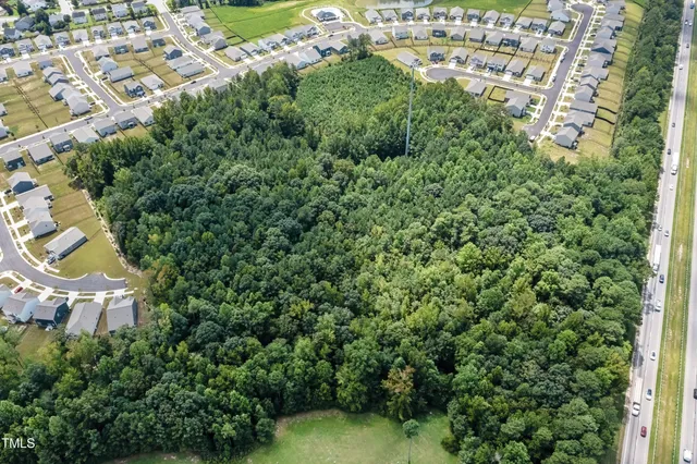 an aerial view of residential house with outdoor space and trees all around