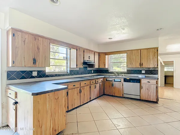 a kitchen with granite countertop sink window and stainless steel appliances