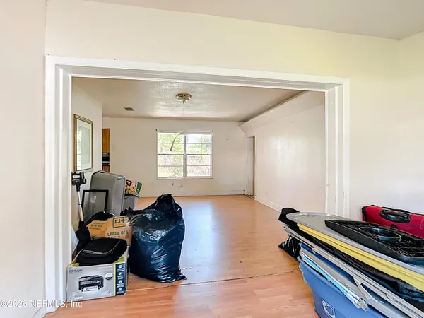 a view of empty room with wooden floor and fan