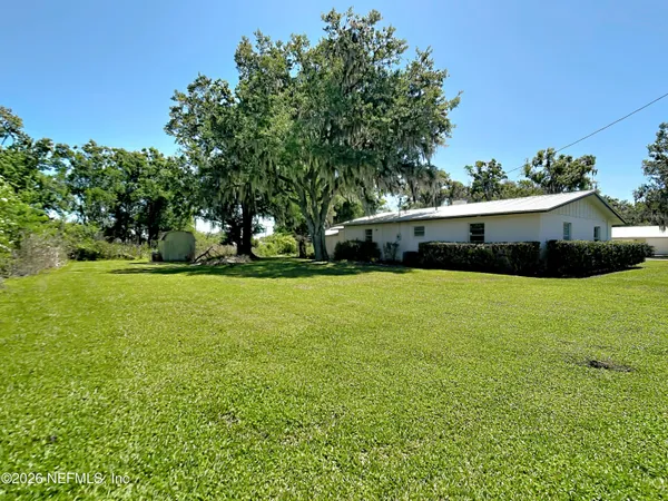 an aerial view of a house with a yard basket ball court and outdoor seating