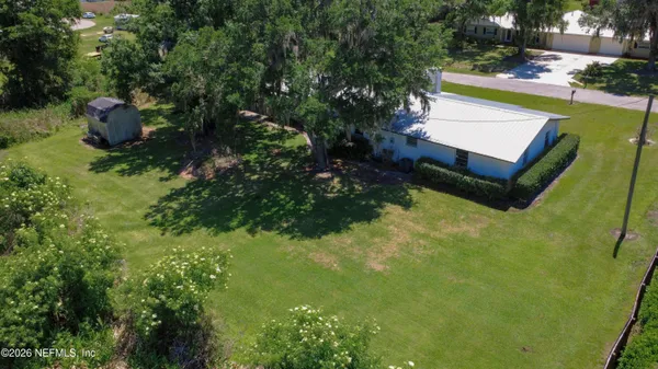 an aerial view of a house with a yard basket ball court and outdoor seating