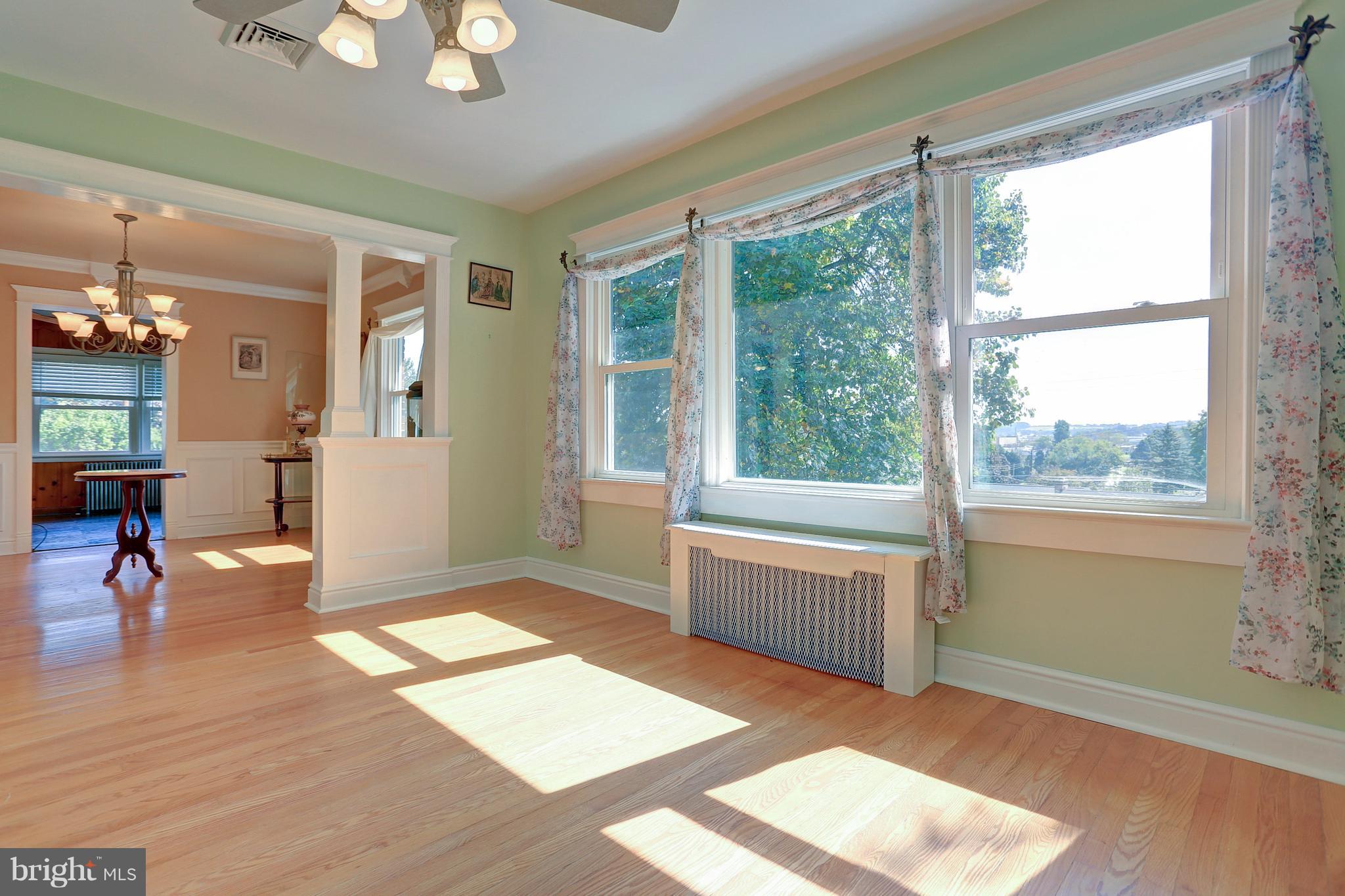 425 Corbin Road York, PA 17403 - Photo 10 of 49 a view of an empty room and kitchen with wooden floor and a large window