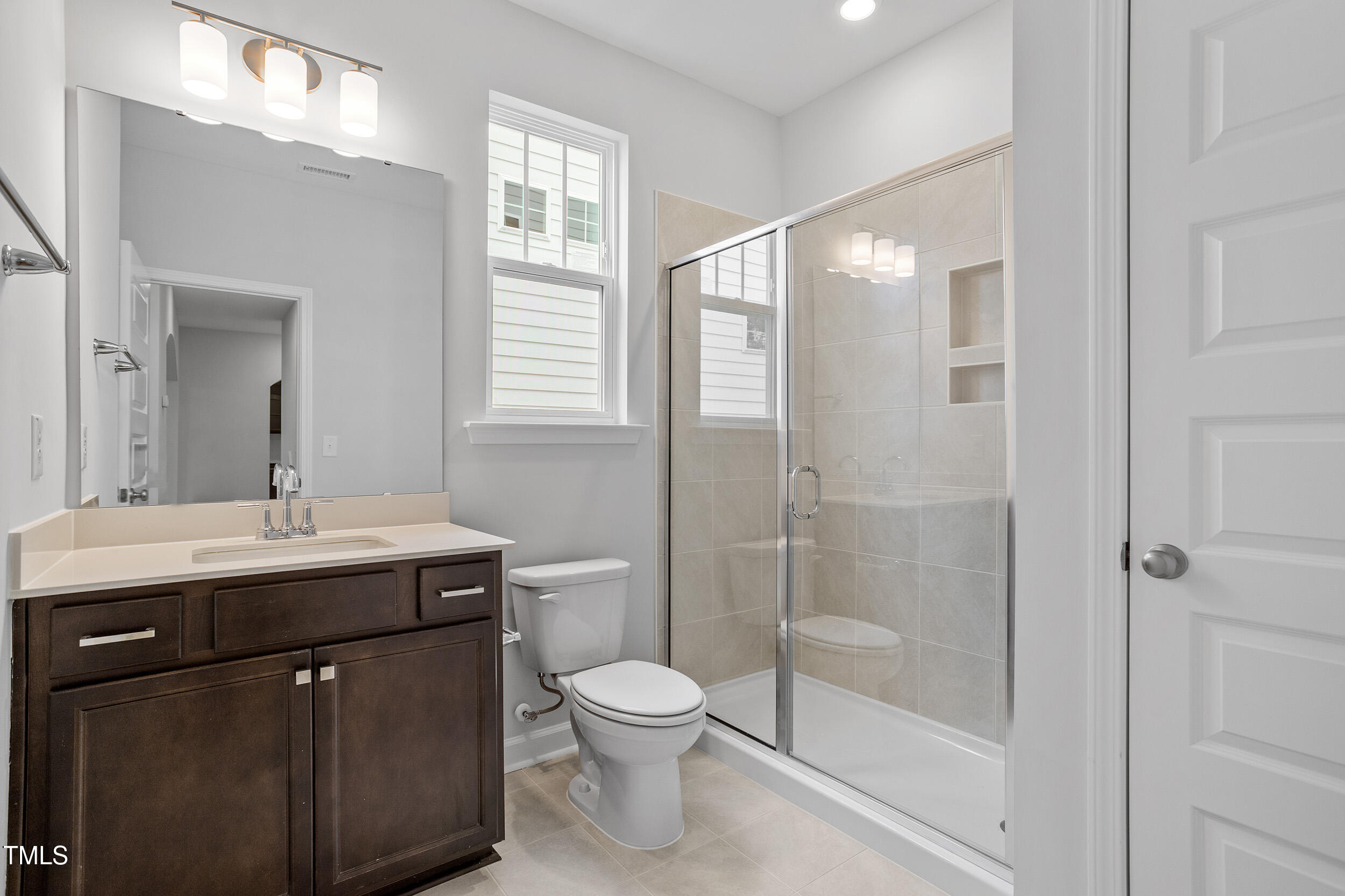 221 Savannah Moss Way, Unit 119 Raleigh, NC 27603 - Photo 21 of 41 a bathroom with a toilet a sink a mirror a window and shower