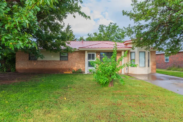 a view of a house with a yard and a garden