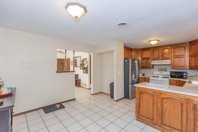 a kitchen with stainless steel appliances a refrigerator sink and microwave