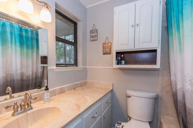 a bathroom with a sink a toilet and a mirror