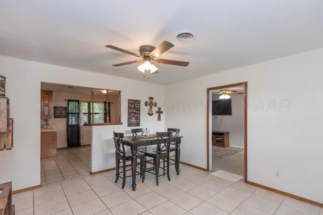 a view of a dining room with furniture and a chandelier fan
