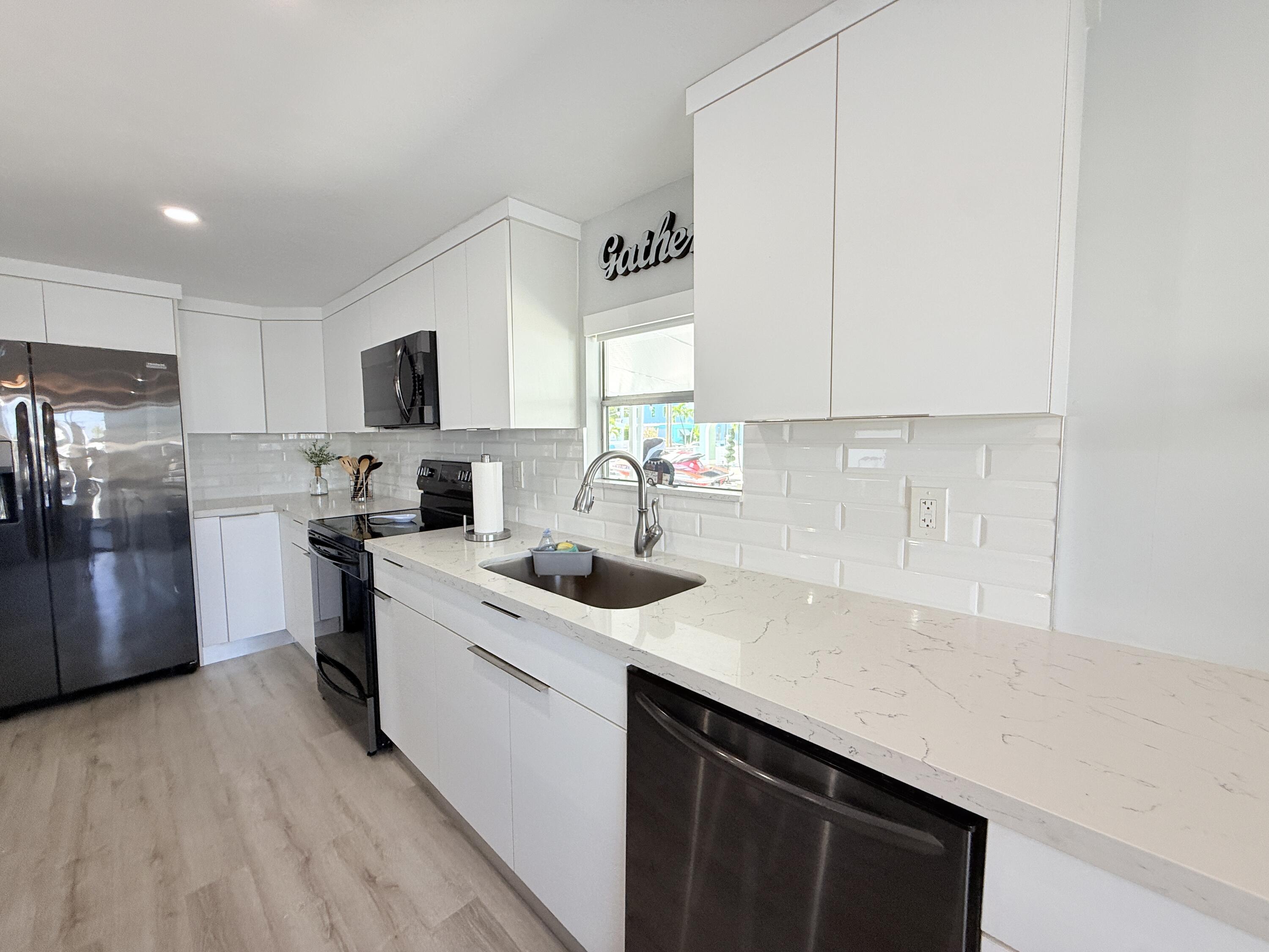 505 Oldsmar Lane Key Largo, FL 33037 - Photo 23 of 61 a kitchen with a sink stove top oven and refrigerator