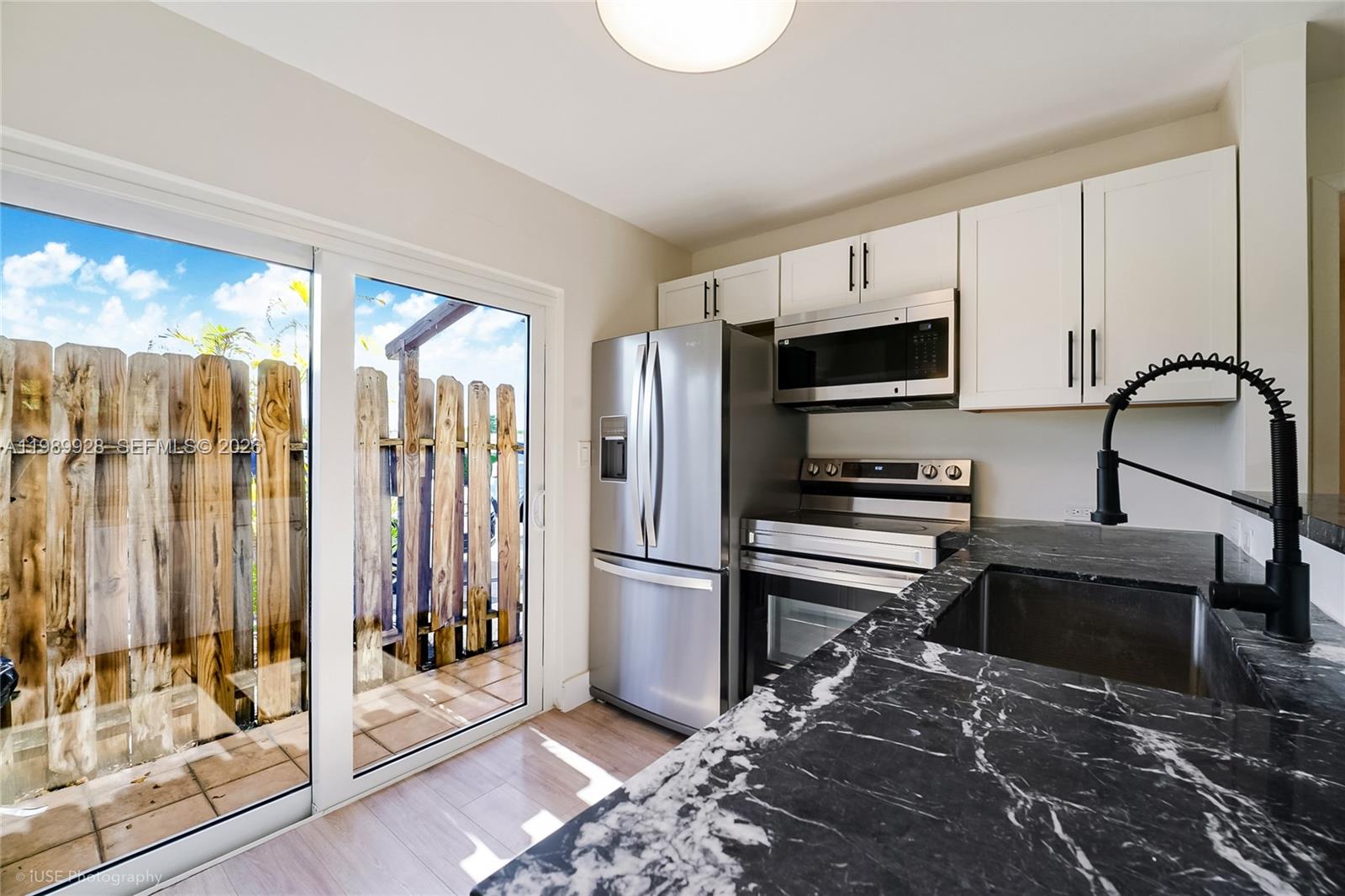 9023 Northeast 4th Avenue Road, Unit 9023 Miami Shores, FL 33138 - Photo 4 of 15 a kitchen with stainless steel appliances granite countertop a refrigerator and a stove top oven