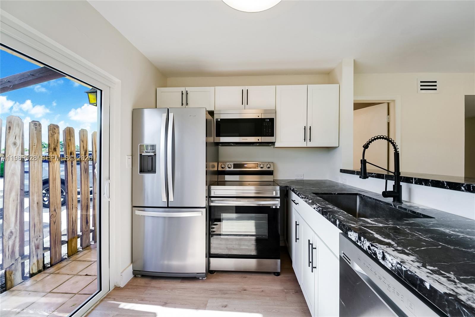 9023 Northeast 4th Avenue Road, Unit 9023 Miami Shores, FL 33138 - Photo 5 of 15 a kitchen with granite countertop a refrigerator stove and sink