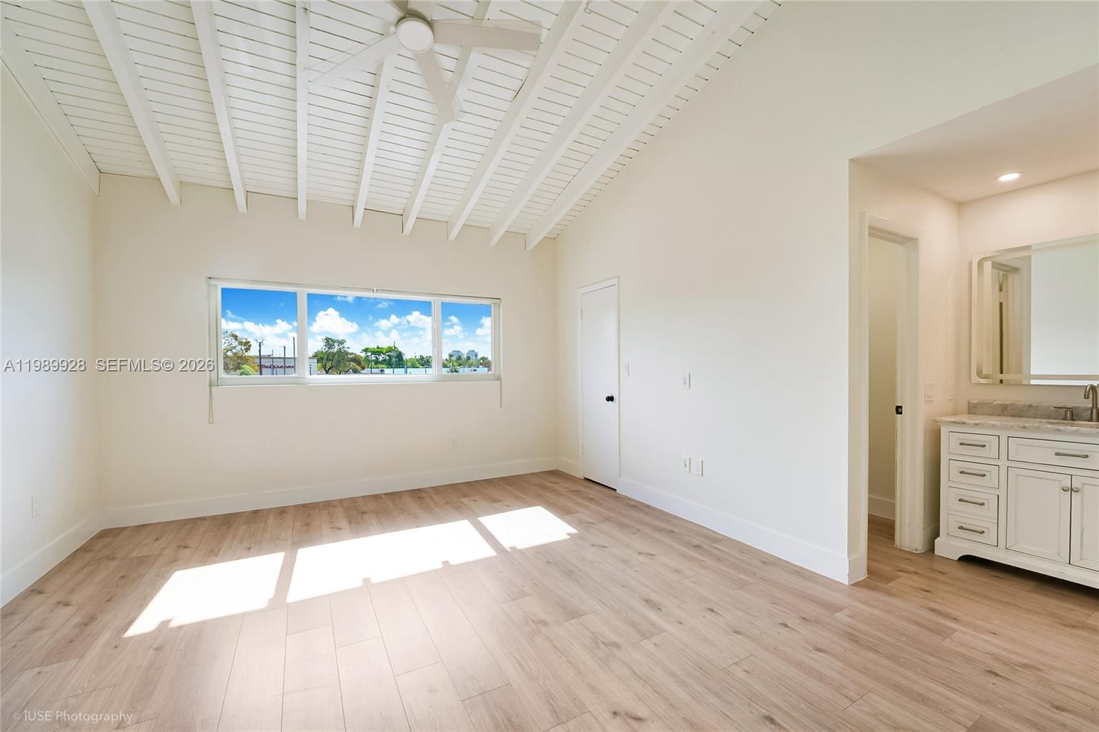 9023 Northeast 4th Avenue Road, Unit 9023 Miami Shores, FL 33138 - Photo 6 of 15 an empty room with wooden floor and windows