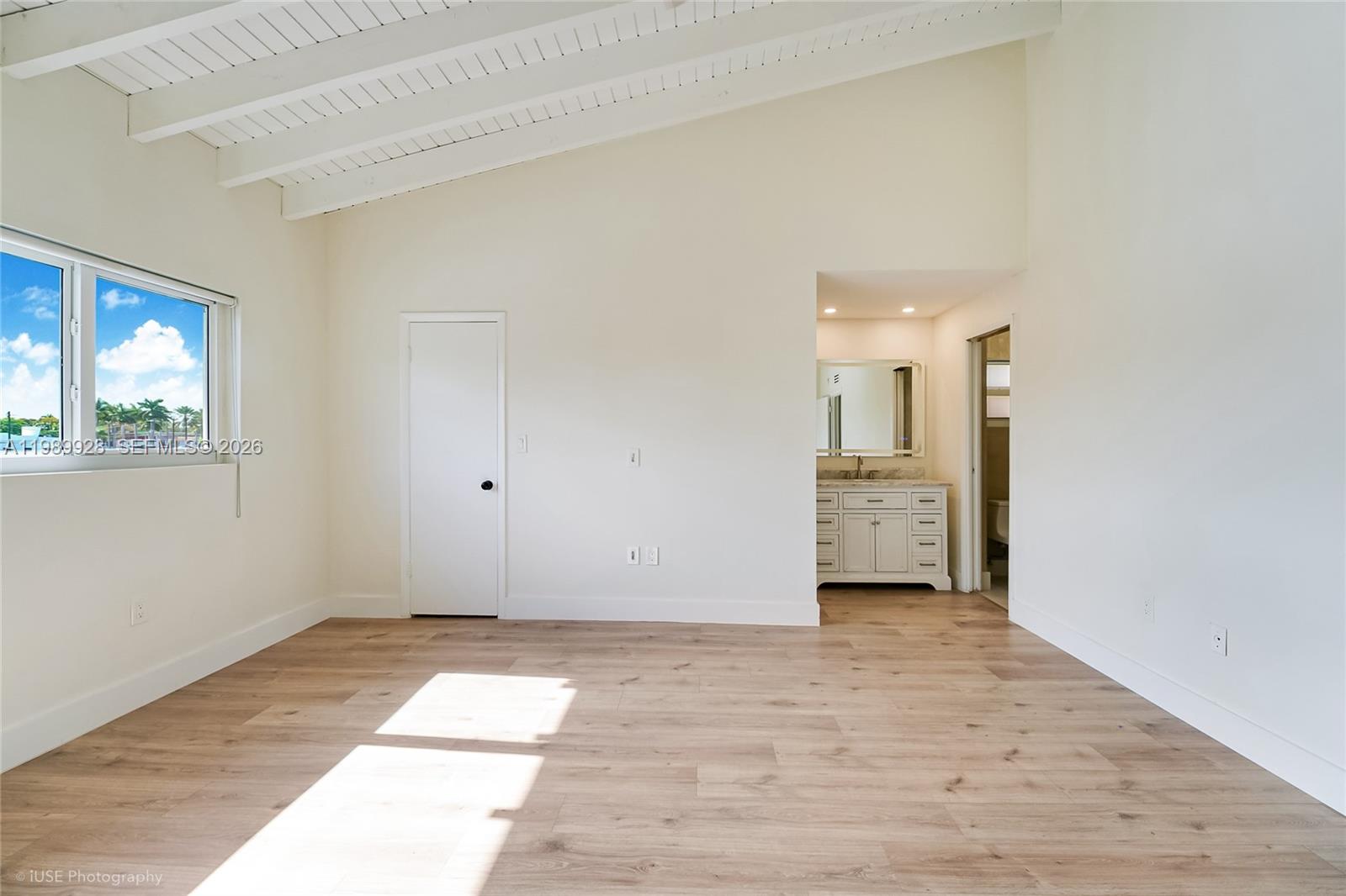 9023 Northeast 4th Avenue Road, Unit 9023 Miami Shores, FL 33138 - Photo 7 of 15 a view of an empty room with wooden floor and a window