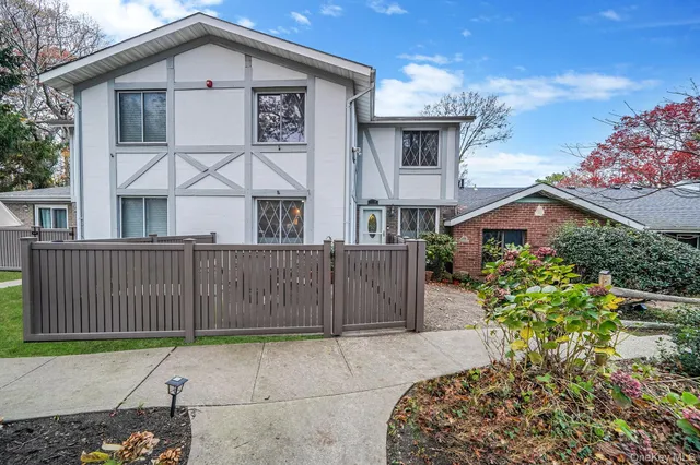 a view of a white house with large windows and a yard
