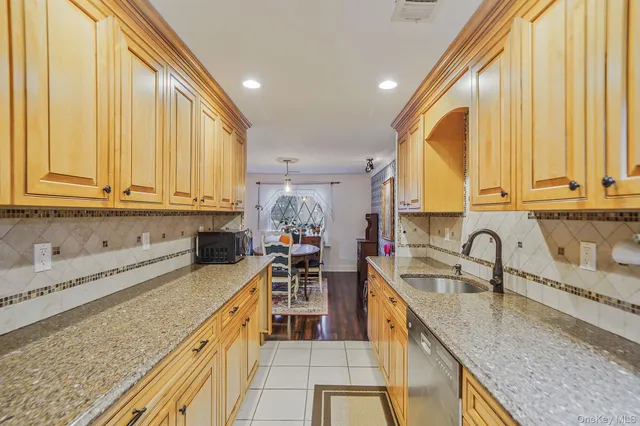a kitchen with stainless steel appliances granite countertop a sink a stove and a wooden cabinets