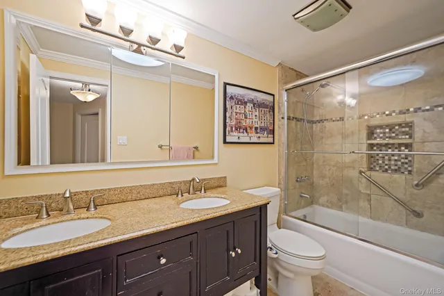 a bathroom with a granite countertop sink toilet mirror and shower