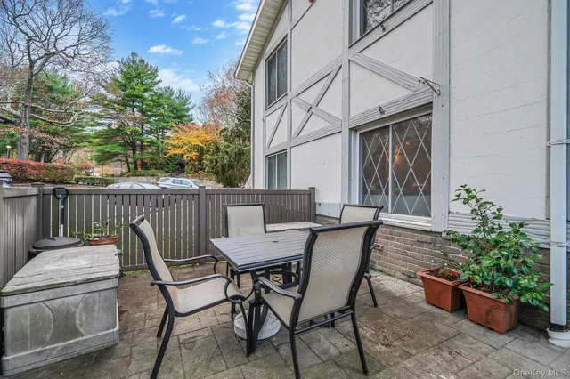 a view of a patio with a table and chairs and potted plants