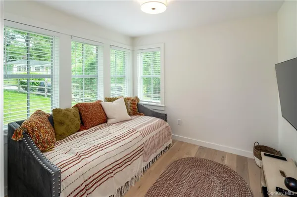 a bathroom with a granite countertop sink a toilet a mirror and shower