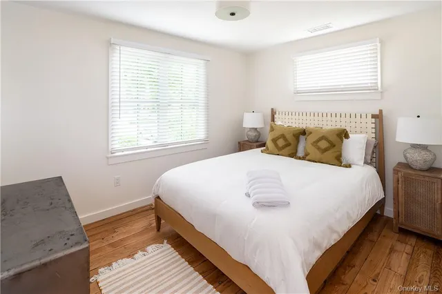 a bedroom with a bed wooden floor and window