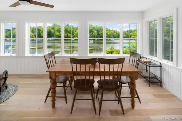 a view of a dining room with furniture large windows and wooden floor