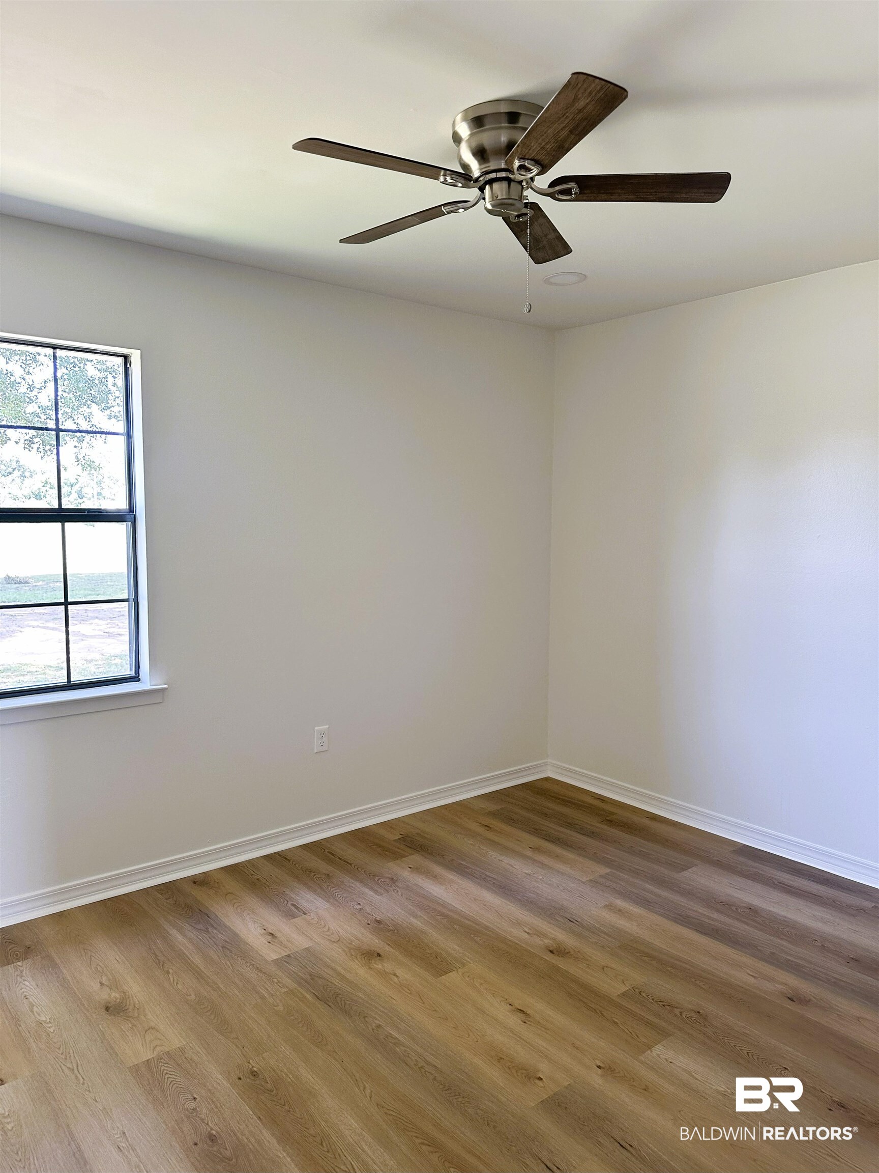 701 McRae Street Atmore, AL 36502 - Photo 5 of 11 Unfurnished room with wood finished floors and a ceiling fan