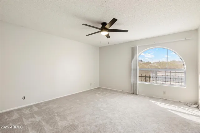 an empty room with closet and ceiling fan