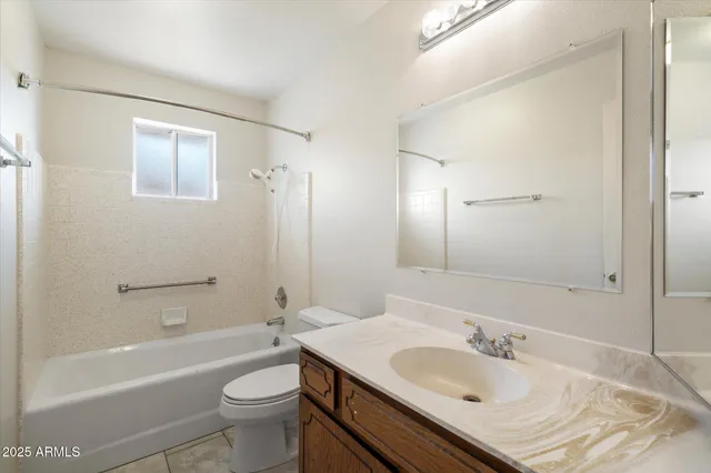 a view of an empty room with a window and a kitchen