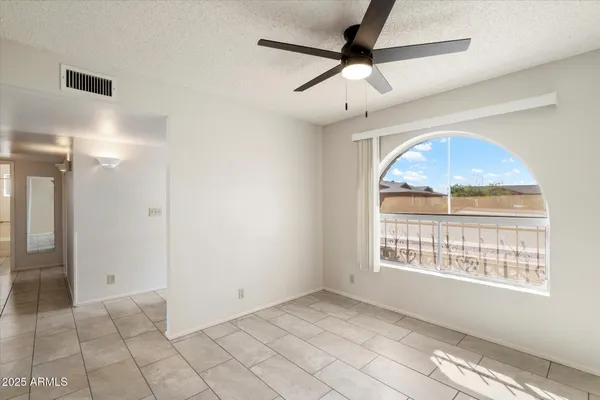an empty room and chandelier fan