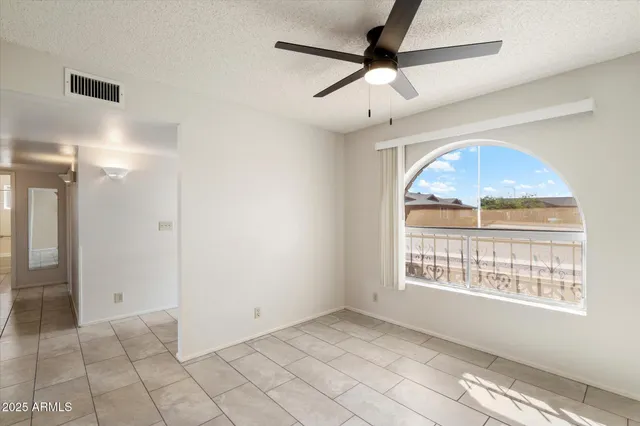 an empty room and chandelier fan