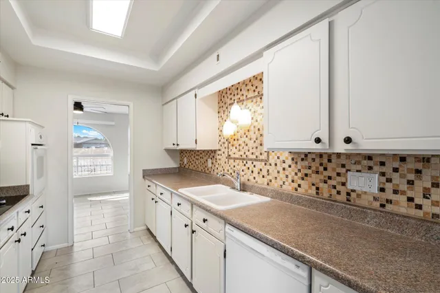 a kitchen with granite countertop a sink stove and refrigerator