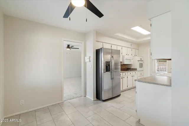 an empty room with a window and ceiling fan