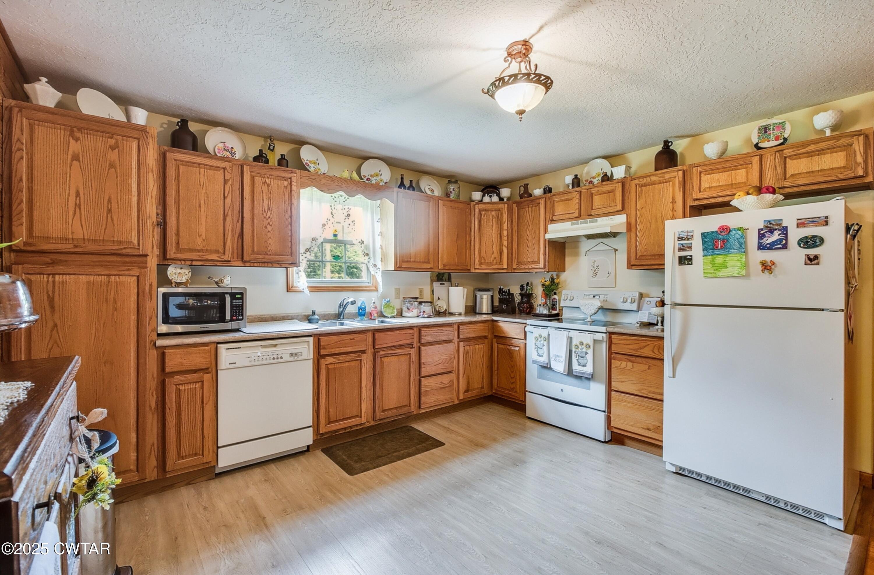95 Stavely Road Medina, TN 38355 - Photo 11 of 33 a kitchen with granite countertop appliances a sink cabinets and a window